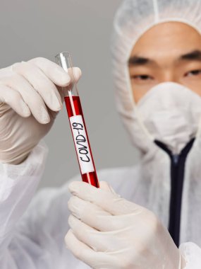 Erkek laboratuvar asistanı koruyucu maske teşhis tedavisini yakından analiz eder