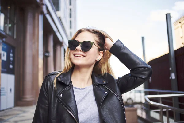 Szczęśliwa kobieta modelka w skórzanej kurtce idzie ulicą — Zdjęcie stockowe