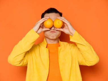 Erkekler soyutlanmış arka planda gözler önünde dudaklarını ve portakallarını büzdü.