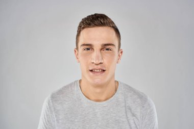 Açık tişörtlü yakışıklı adam manzaralı. Duygusal stüdyo izole edilmiş.