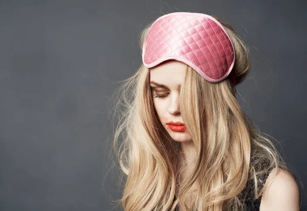 Portrait of a blonde in a sleep mask and bright makeup lipstick smeared on her face — Stock Photo, Image