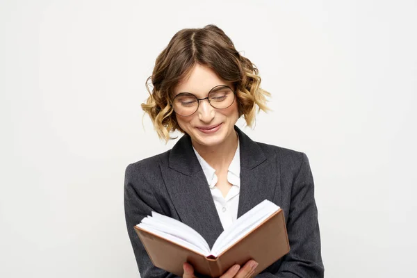 Donna al lavoro con libro in mano luce sfondo classico vestito occhiali testa — Foto Stock