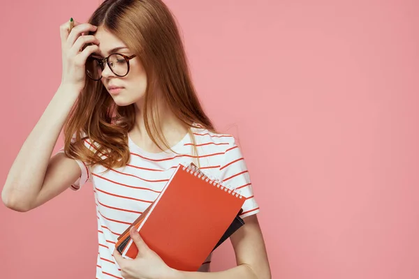 Young female student with books on pink background glasses on face education institute cropped view — Stock Photo, Image