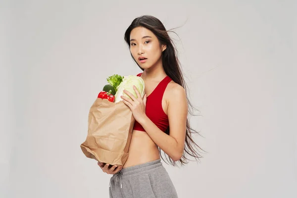 Mujer con paquete de alimentos figura delgada vegetariano —  Fotos de Stock