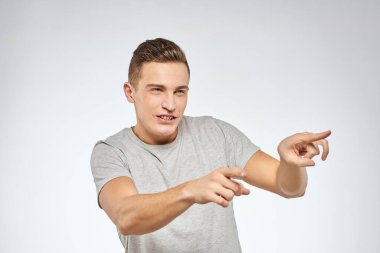 Gri tişörtlü yakışıklı adam duygu stüdyosu modelini kesmiş.