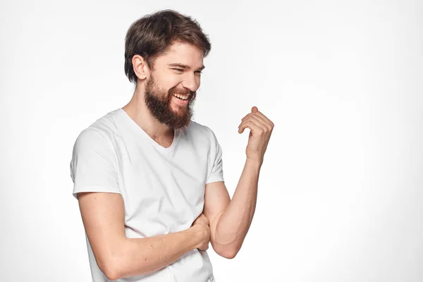 Bearded man i vit t-shirt gest med händer känslor ljus bakgrund — Stockfoto