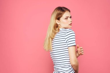 Çizgili tişört giymiş bir kadın stüdyosunun pembe izole edilmiş yaşam tarzını izledi.