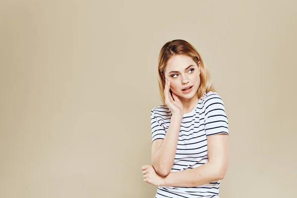 Mujer alegre rayas camiseta estudio beige fondo estilo de vida emociones —  Fotos de Stock