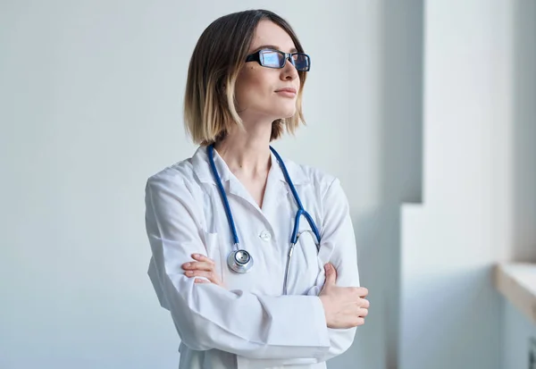 professional doctor woman with glasses near window and stethoscope