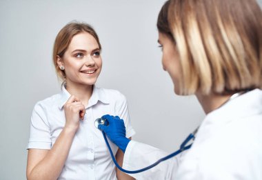 Steteskoplu bir doktor ve arka planda mutlu bir hasta.