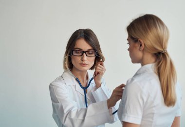 Doktor, hastaların kalp atışlarını steteskopla dinler.