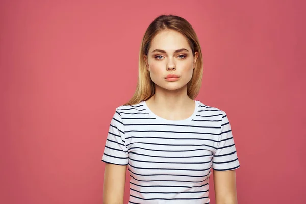 Vrolijke vrouw gestreepte t-shirt lifestyle emoties en gebaren met handen roze achtergrond — Stockfoto