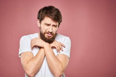 duygusal adam beyaz t-shirt üzgün yüz ifadesi pembe arka plan