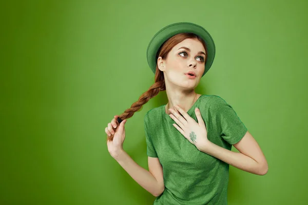 Bella ragazza con un trifoglio sulla mano su uno sfondo verde vacanze St. Patricks Day divertente cappello sulla testa — Foto Stock