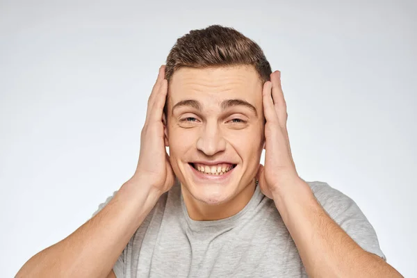 Cheerful emotional man gray t-shirt gesturing with hands studio lifestyle — Stock Photo, Image