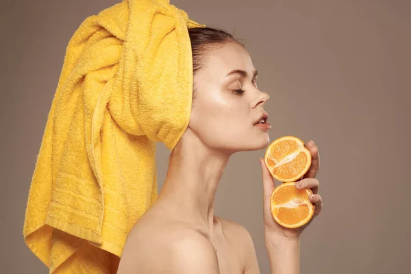 Mulher bonita toalha amarela em cosméticos naturais laranja Fundo bege exótico — Fotografia de Stock