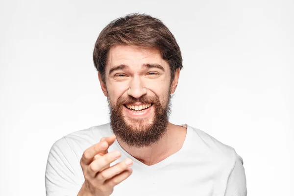 Веселий емоційний бородатий чоловік жестикулює руками крупним планом світлий фон — стокове фото