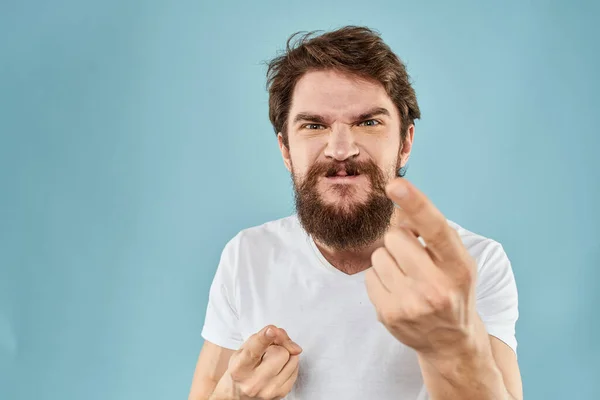 Бородатий чоловік у білій футболці емоції жести з руками невдоволений вираз обличчя синій фон — стокове фото