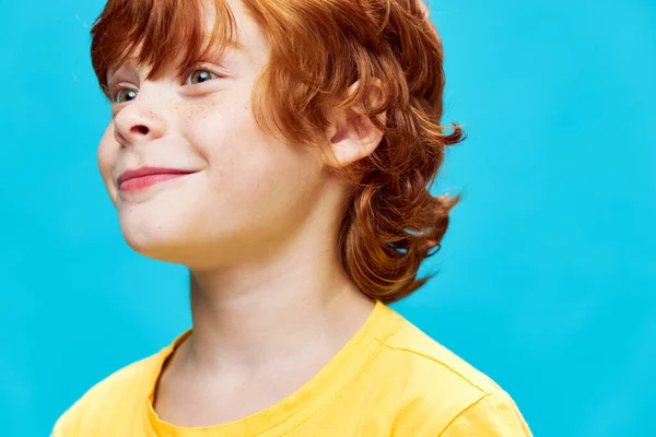 Lächelnder rothaariger Junge, der zur Seite schaut, gelbes T-Shirt-Studio — Stockfoto