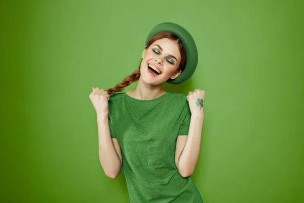 Bella ragazza con un trifoglio sulla mano su uno sfondo verde vacanze St. Patricks Day divertente cappello sulla testa — Foto Stock