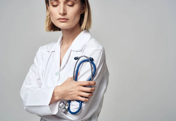Женщина в белом халате доктор и стетоскоп в руке — стоковое фото