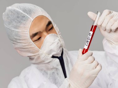 Erkek Asyalı görünüm laboratuvarı teşhis kovid-19 'u analiz ediyor.
