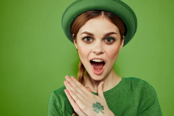 Belle fille avec un trèfle sur sa main sur un fond vert vacances St. Patricks Day chapeau amusant sur sa tête — Photo