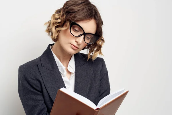 Mujer de negocios en un traje clásico con un cuaderno en la mano y gafas en la cara Copiar espacio —  Fotos de Stock