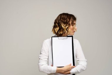 Açık tişörtlü bir iş kadını ve dosyasının içinde iş görüşü kesilmiş belgeler var.