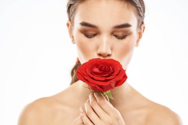 Yüzü makyajlı ve elinde kırmızı bir gül olan çekici esmer kız.