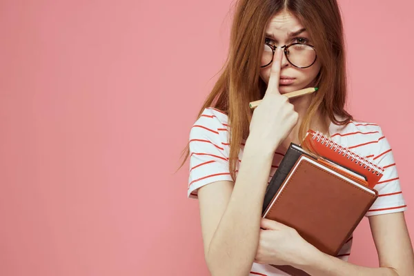 Jeune étudiante avec des livres sur les lunettes de fond roses sur le visage institut d'éducation vue recadrée — Photo