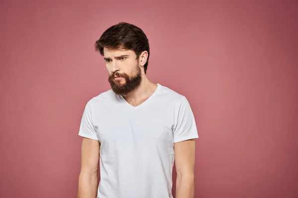 Man i vit t-shirt känslor livsstil ansiktsuttryck beskärd vy rosa bakgrund. — Stockfoto