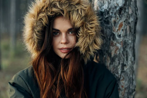 Mujer en una chaqueta con una capucha cerca de un árbol atractivo look close-ups naturaleza —  Fotos de Stock