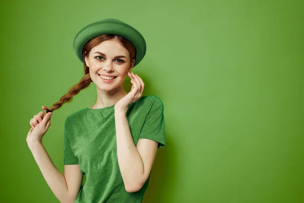 Donna felice con trifoglio il giorno di San Patrizio in abiti verdi e un cappello sulla testa gesticolando con le mani — Foto Stock