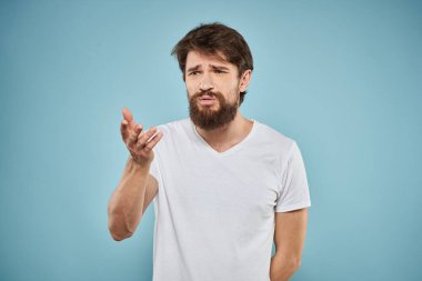 Beyaz tişörtlü adam yaşam tarzı stüdyo duyguları yüz ifadesi mavi izole arkaplan