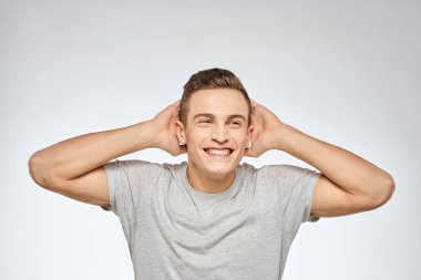 Gri tişörtlü yakışıklı adam duygu stüdyosu modelini kesmiş.