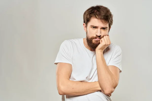 Uomo in bianco t-shirt gesticolando con le mani studio insoddisfazione stile di vita luce sfondo — Foto Stock