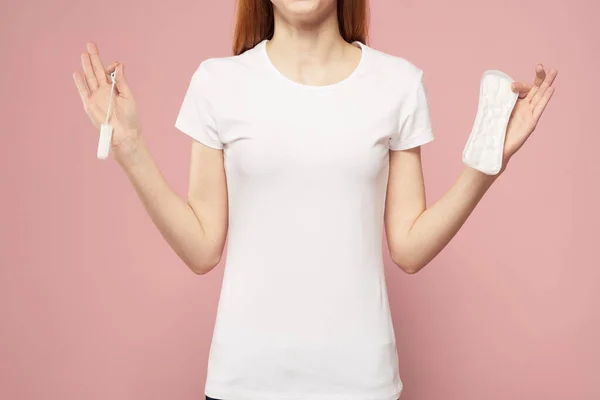 Mädchen mit einer Unterlage und Tampons in der Hand rosa Hintergrund Menstruation kritischen Tagen Hygiene — Stockfoto