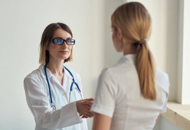 Hasta, arka planda steteskopla doktora geldi.