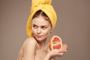Kafasında sarı havluyla güzel bir kadın egzotik meyveli narenciye vitaminleri.