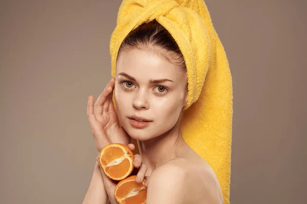 Mulher bonita com toalha amarela em sua cabeça laranjas pele limpa vista cortada — Fotografia de Stock