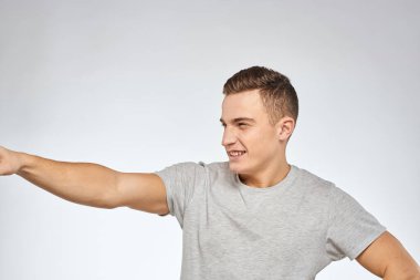 Gri tişörtlü yakışıklı adam duygu stüdyosu modelini kesmiş.