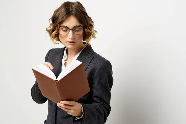 Femme au travail avec livre à la main lumière arrière-plan classique costume lunettes tête — Photo