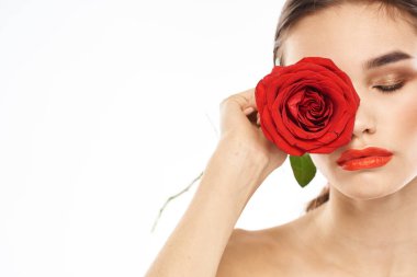 Yüzü makyajlı ve elinde kırmızı bir gül olan çekici esmer kız.
