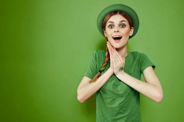 Femme heureuse avec trèfle le jour de la Saint-Patricks en vêtements verts et un chapeau sur sa tête gesticulant avec ses mains — Photo