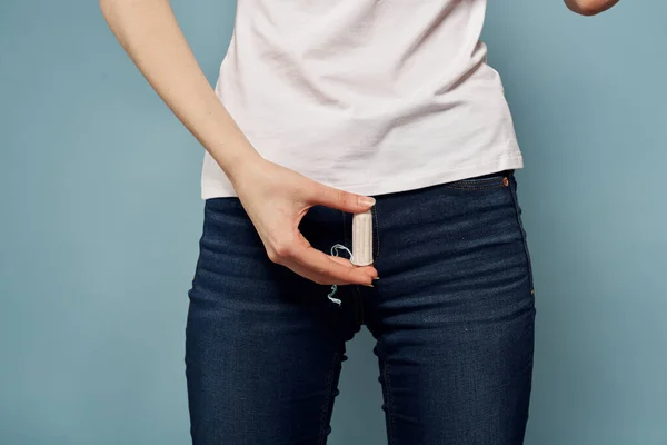 Mujer con tampón y jeans camiseta menstruación fondo azul recortado ver higiene — Foto de Stock