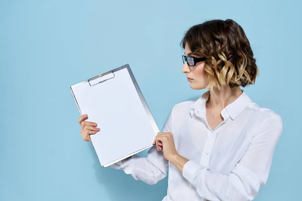 Donna d'affari con documenti in una cartella su sfondo blu e in occhiali di camicia leggera sul viso — Foto Stock