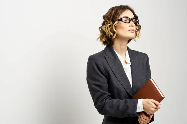 Mujer de negocios en un traje clásico con un cuaderno en la mano y gafas en la cara Copiar espacio — Foto de Stock