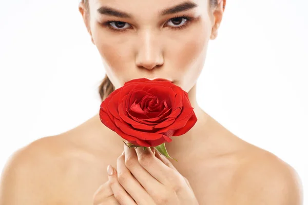 Okouzlující brunetka dívka s make-upem na tváři a červenou růži v ruce — Stock fotografie
