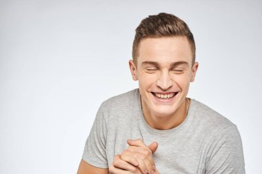 Neşeli, duygusal, gri tişörtlü, el hareketli stüdyo yaşam tarzı.